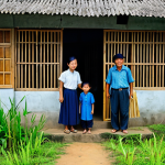 Safe Shelter**

"A modest family in appropriate clothing inside a fortified farmhouse in the Vietnamese countryside, safe for work, correct proportions, well-formed hands, natural body proportions, fully clothed, professional lighting, clear and bright, appropriate content. The farmhouse features reinforced windows with metal bars and a sturdy wooden door. They are surrounded by a bamboo fence. The scene conveys a sense of security and resourcefulness, family-friendly."

**